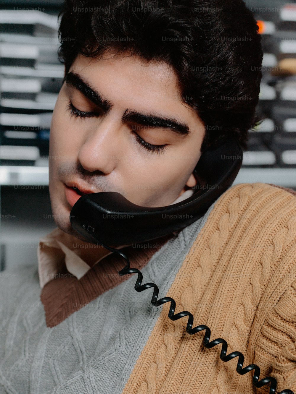 ein Mann mit einem Telefon vor dem Gesicht