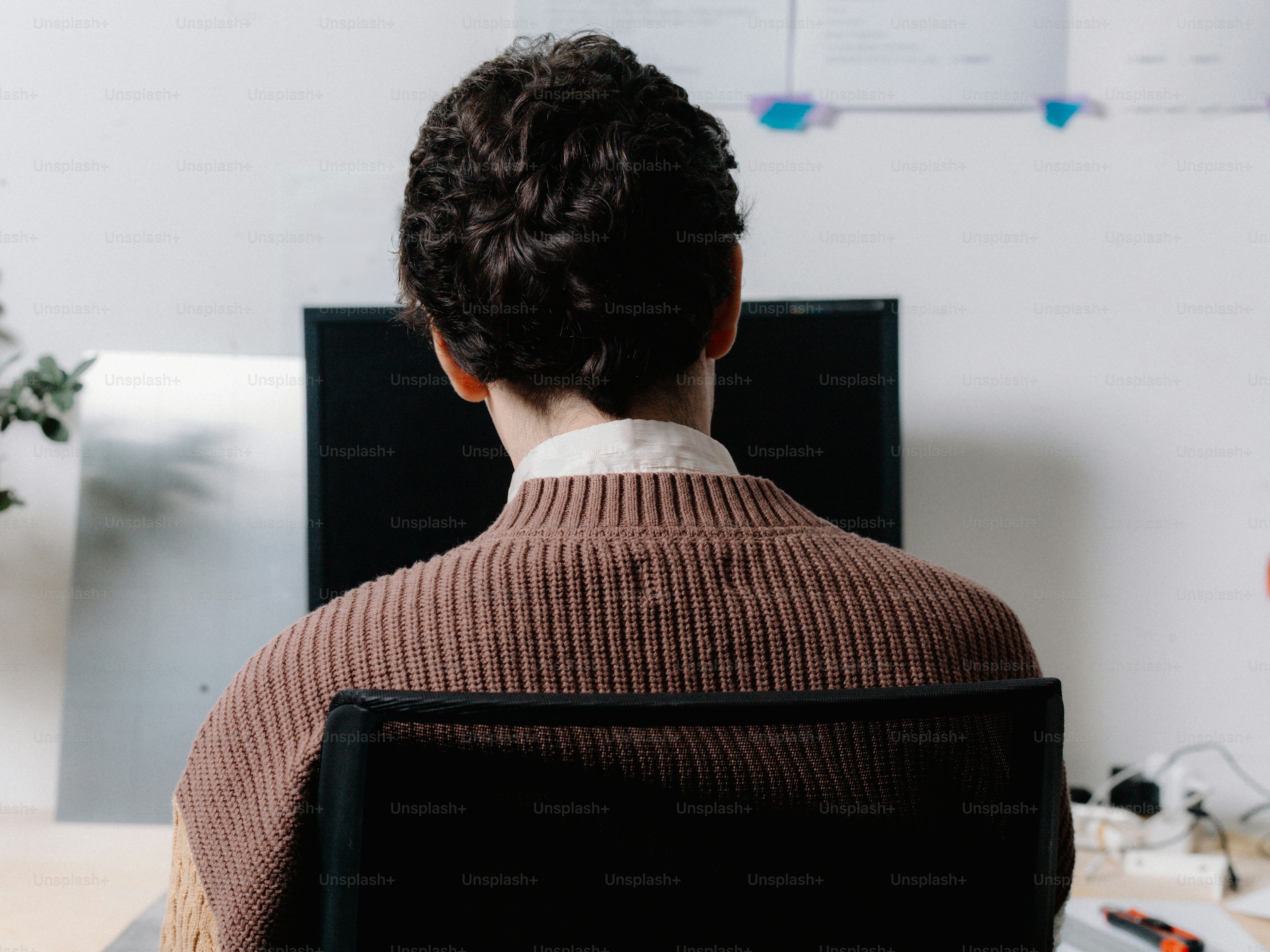 una persona sentada en una silla frente a una computadora