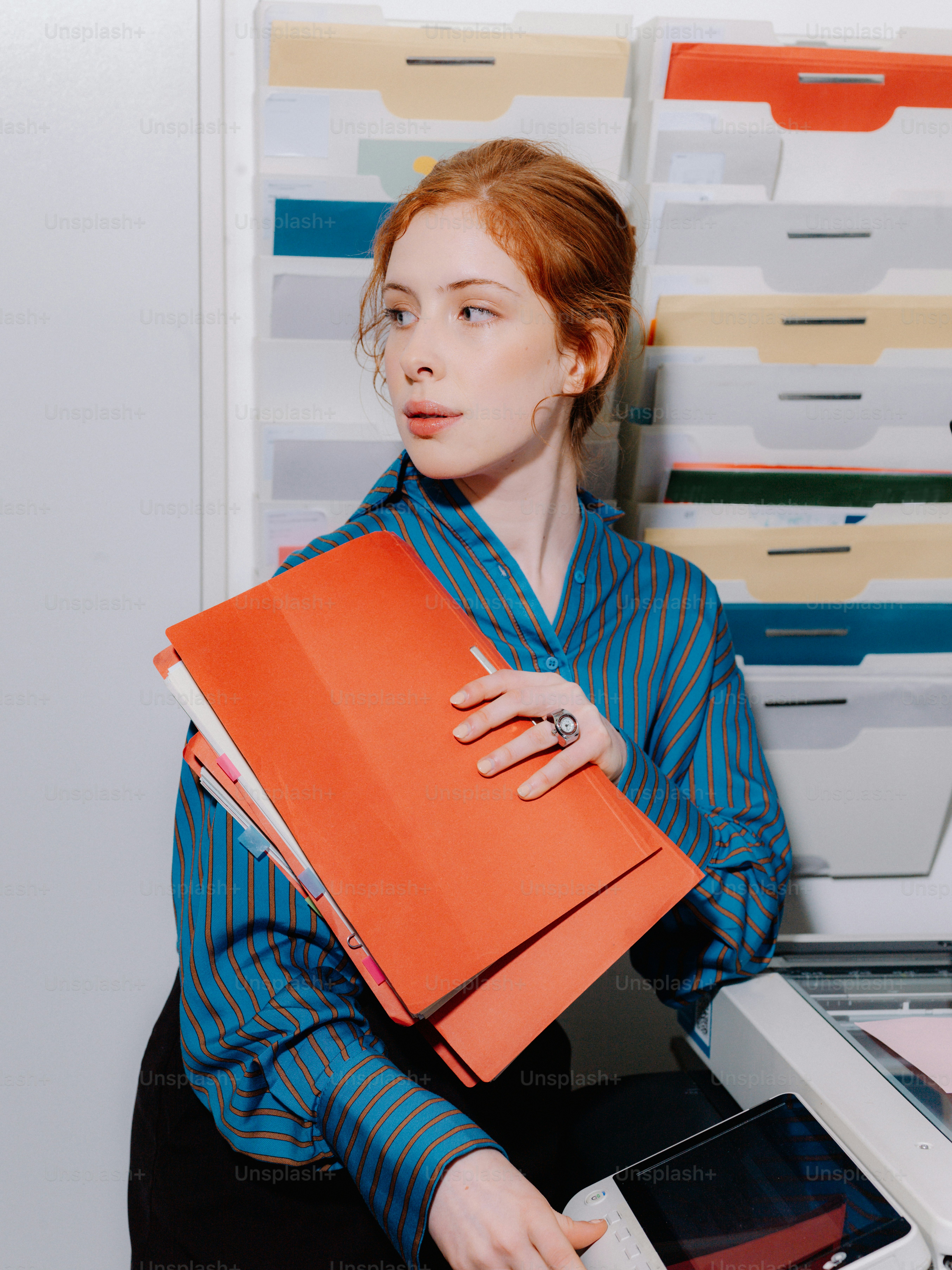 a woman holding a binder and a laptop computer