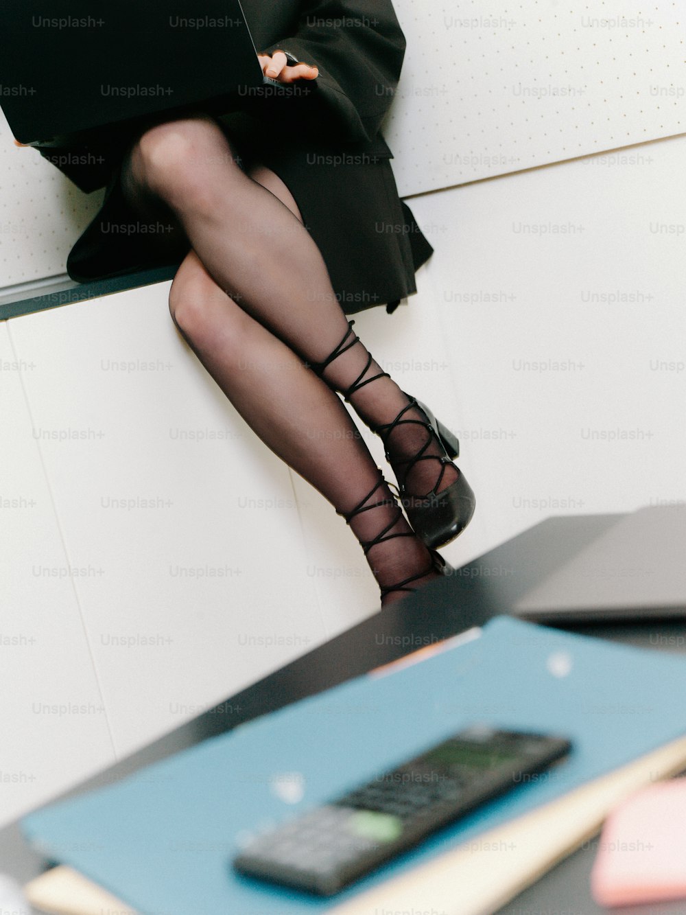 une femme assise sur un bureau avec un ordinateur portable