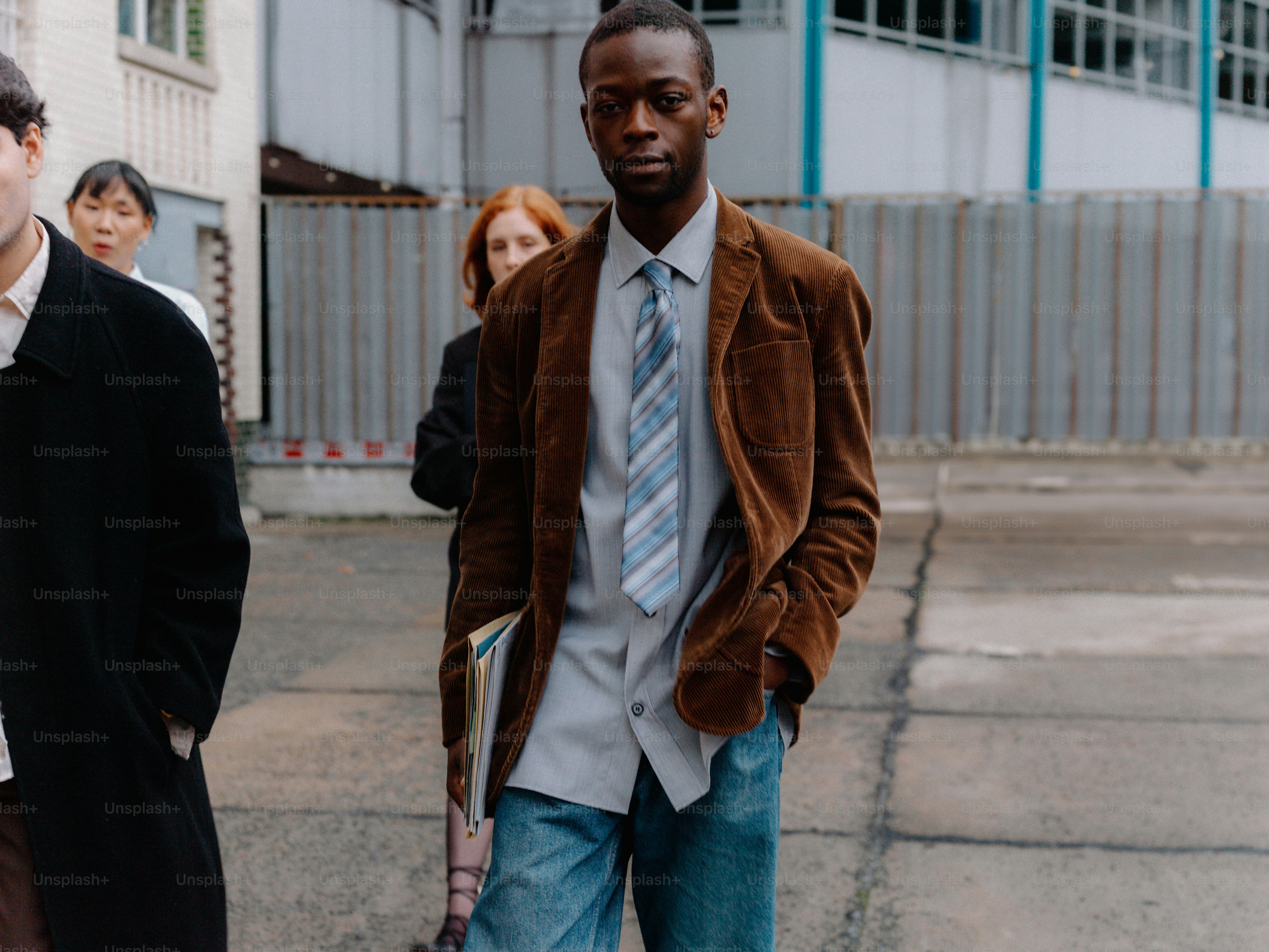 un uomo in giacca e cravatta marrone che cammina per strada