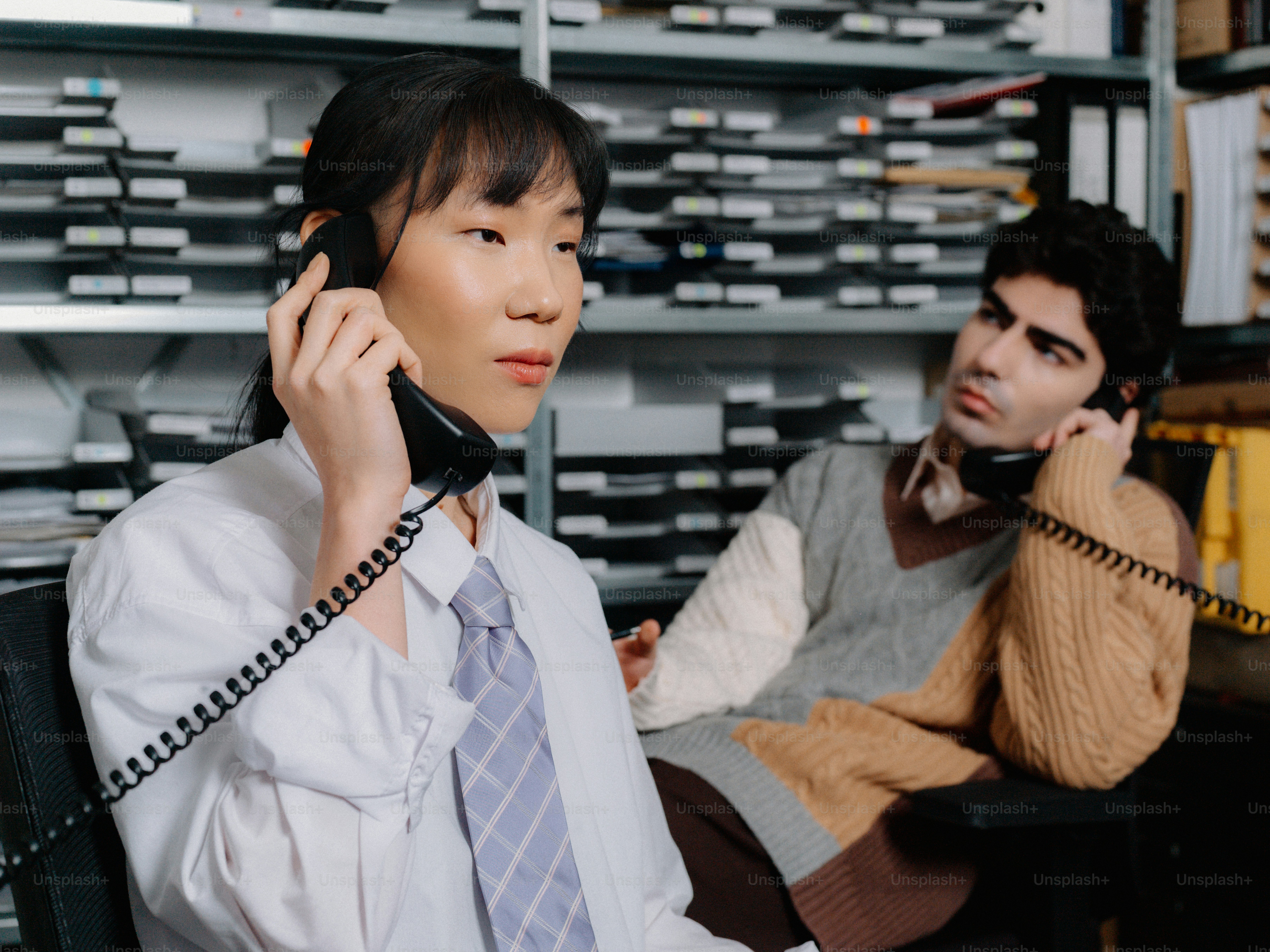 a man sitting in a chair while talking on a phone