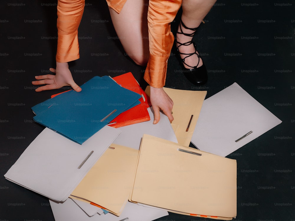 a person reaching for papers on the floor
