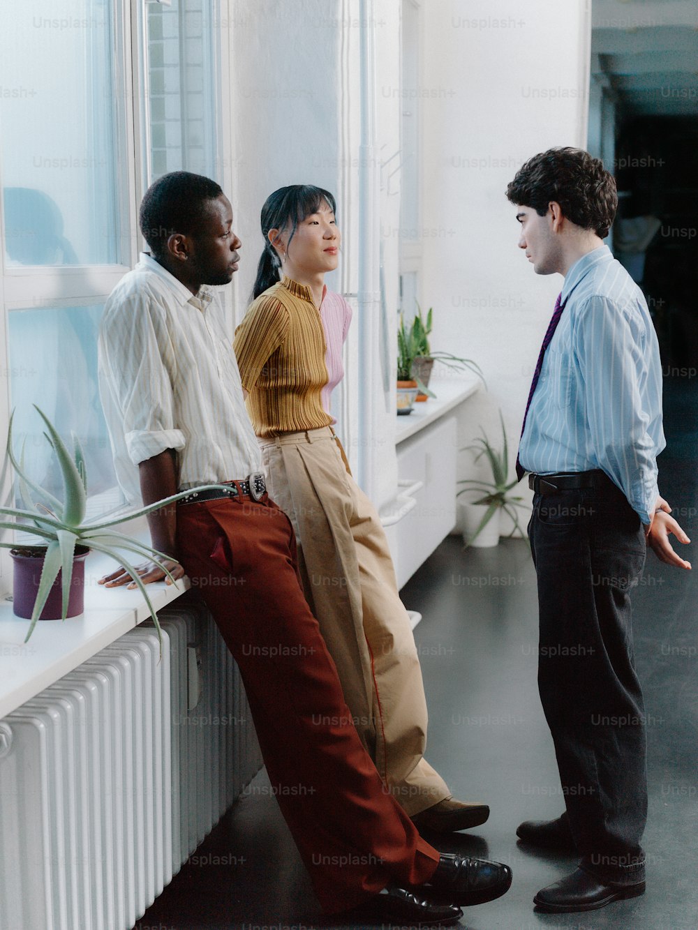 a group of men standing next to each other near a window