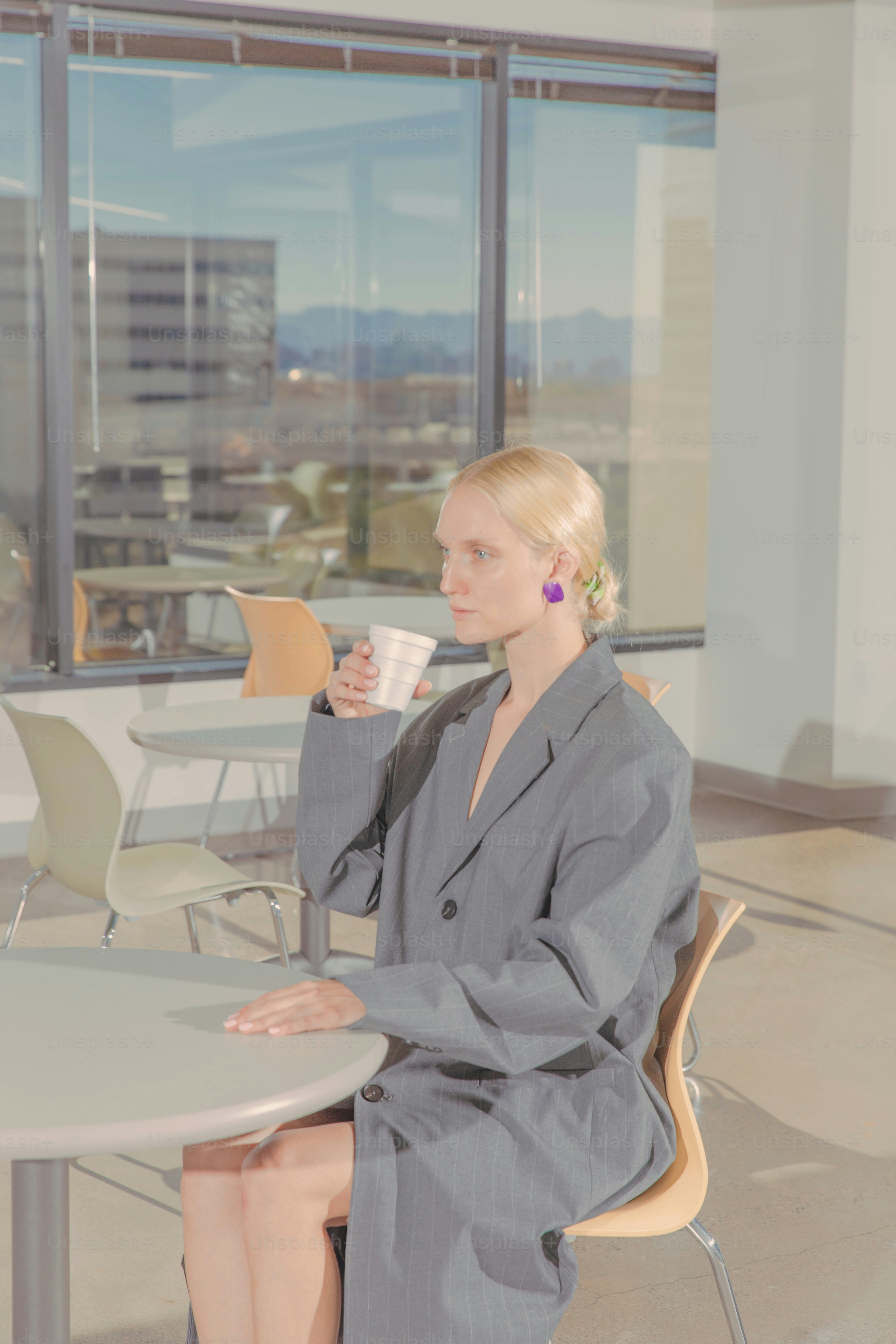 una donna seduta a un tavolo con una tazza di caffè