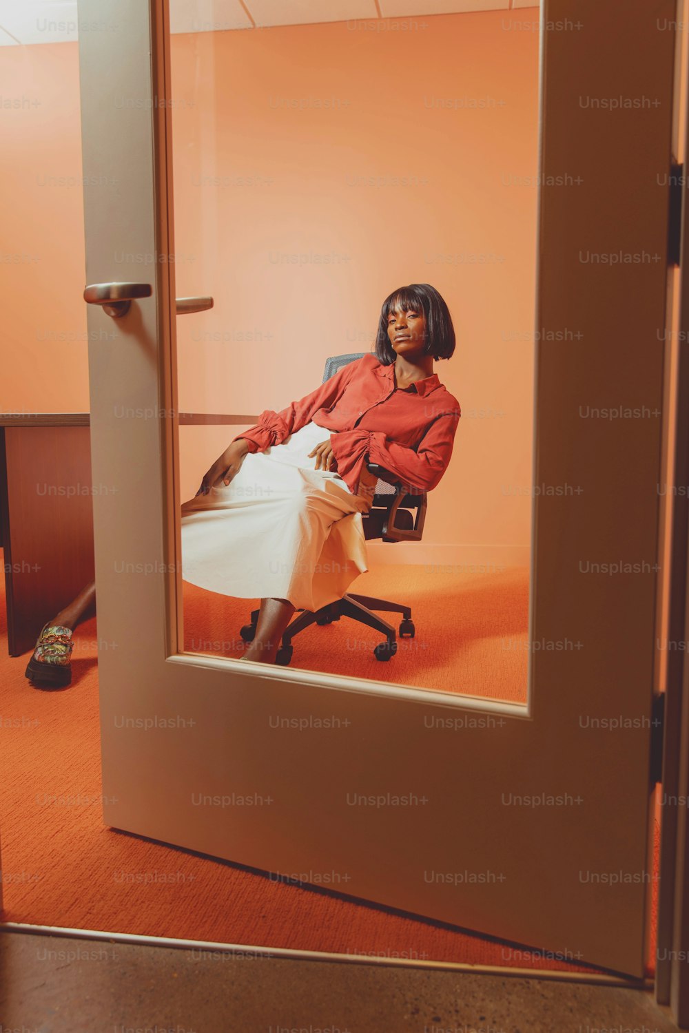 a woman sitting in a chair in an orange room