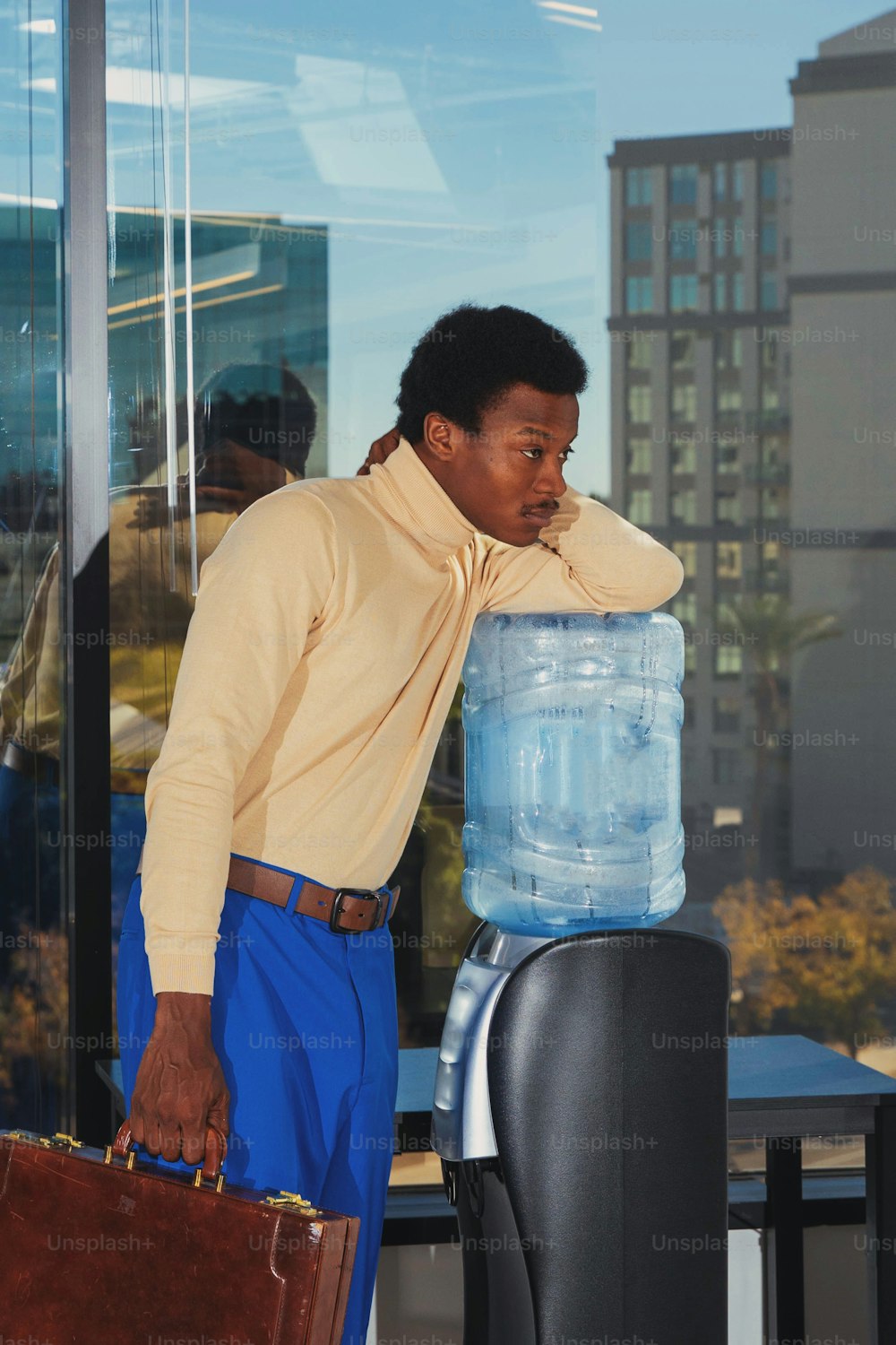 Un hombre sosteniendo un maletín y una botella de agua grande