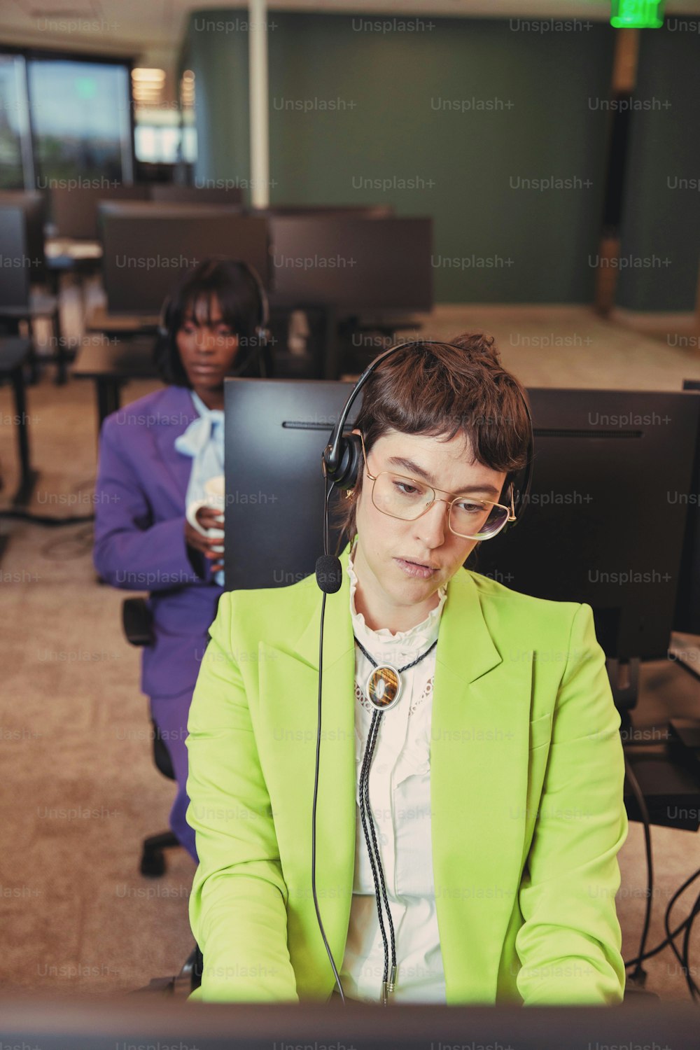 una mujer sentada en un escritorio con los auriculares puestos