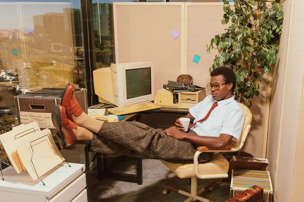 un uomo seduto su una sedia di fronte alla scrivania di un computer