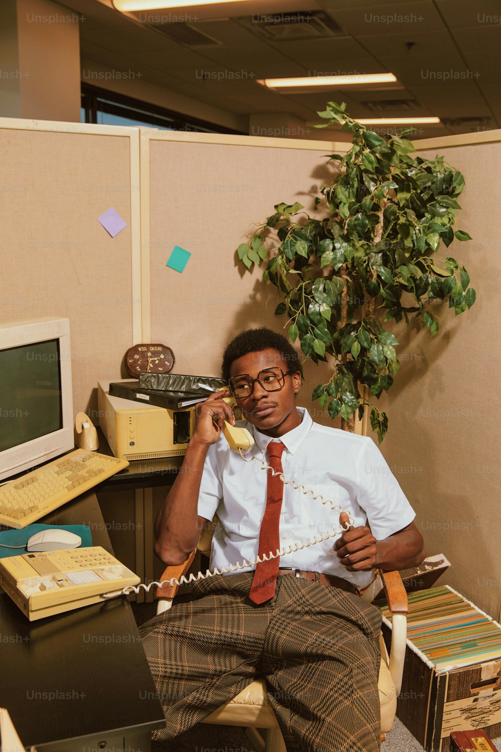 un homme assis à un bureau en train de parler au téléphone