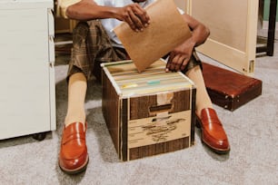 a man sitting on the floor with a piece of cardboard