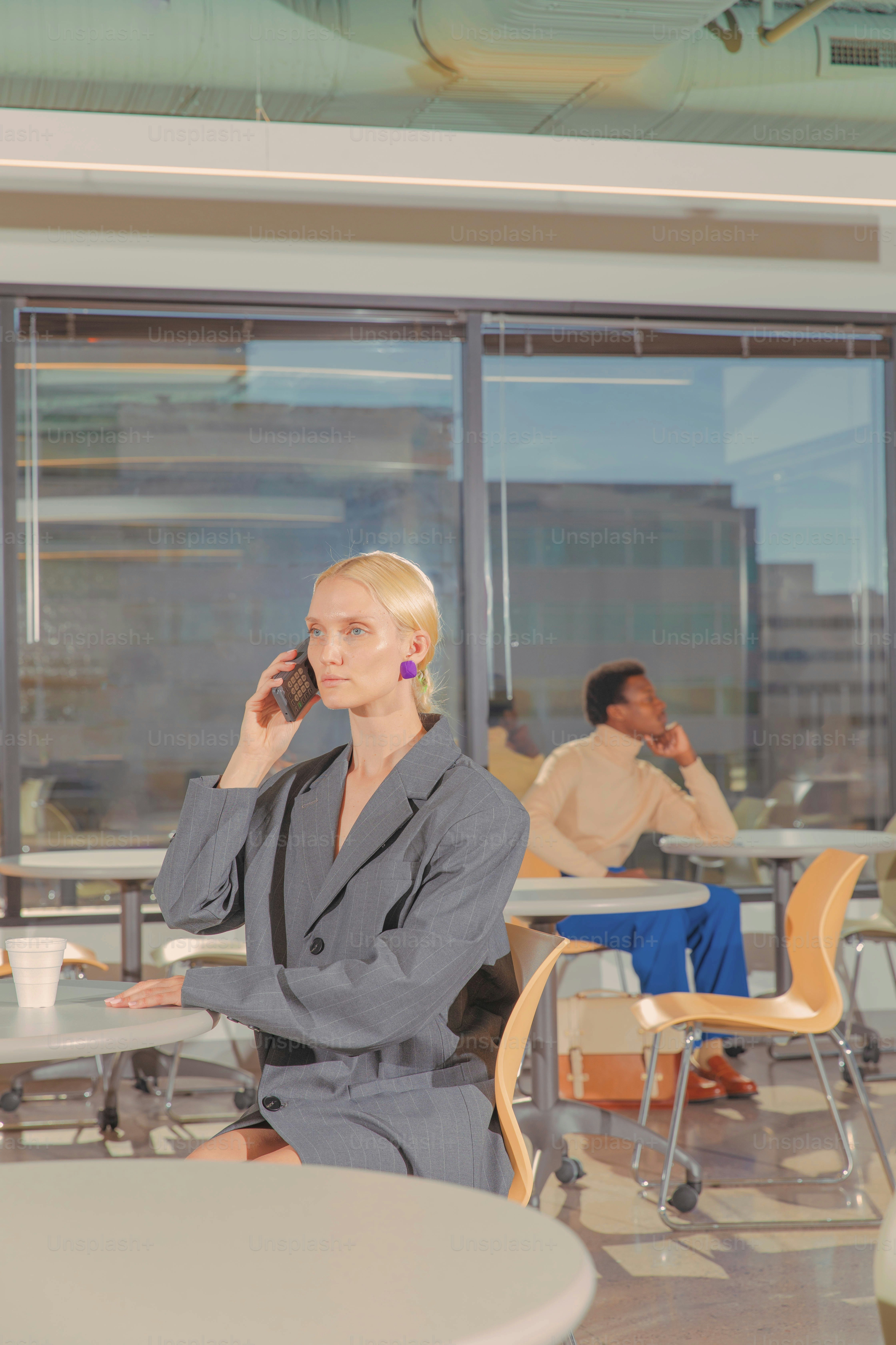 a woman sitting at a table talking on a cell phone