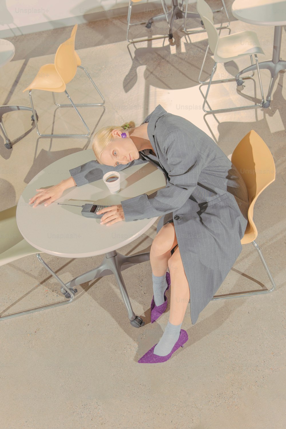 a woman sitting at a table with a cup of coffee