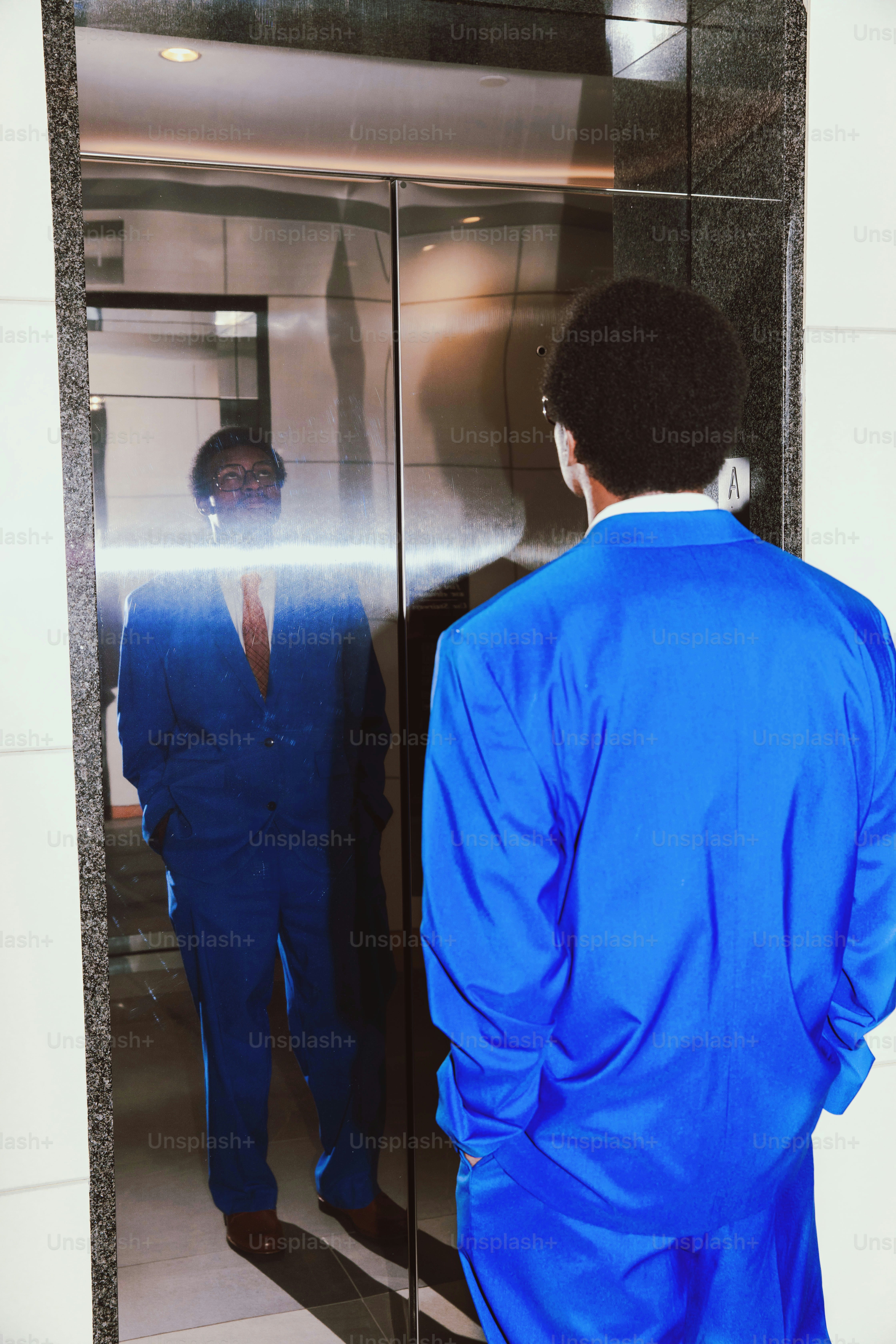 Ein Mann in einem blauen Anzug steht in einem Aufzug