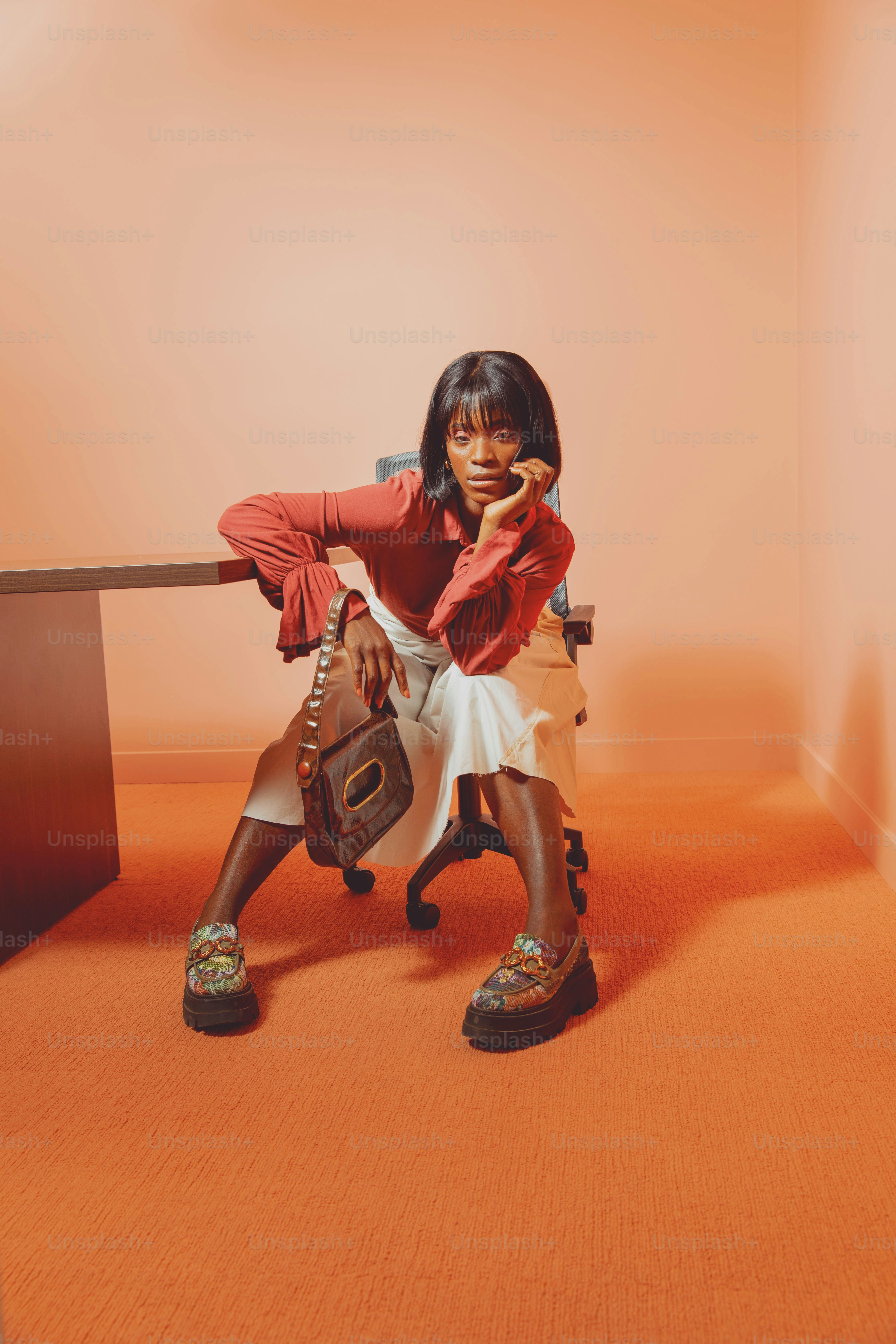 a woman sitting on a chair holding a baseball glove