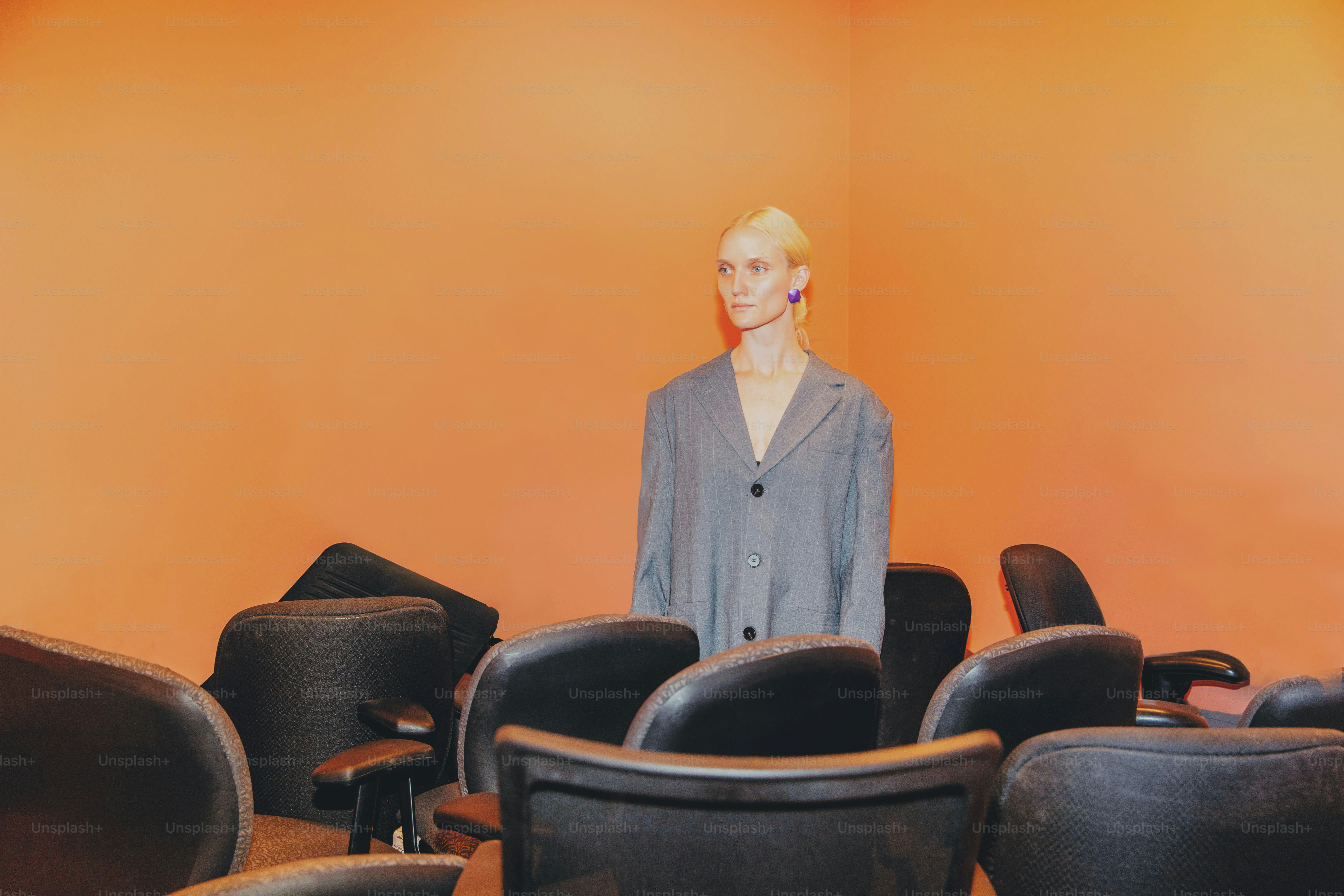 a woman standing in front of a room full of chairs