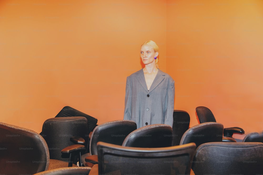 a woman standing in front of a room full of chairs