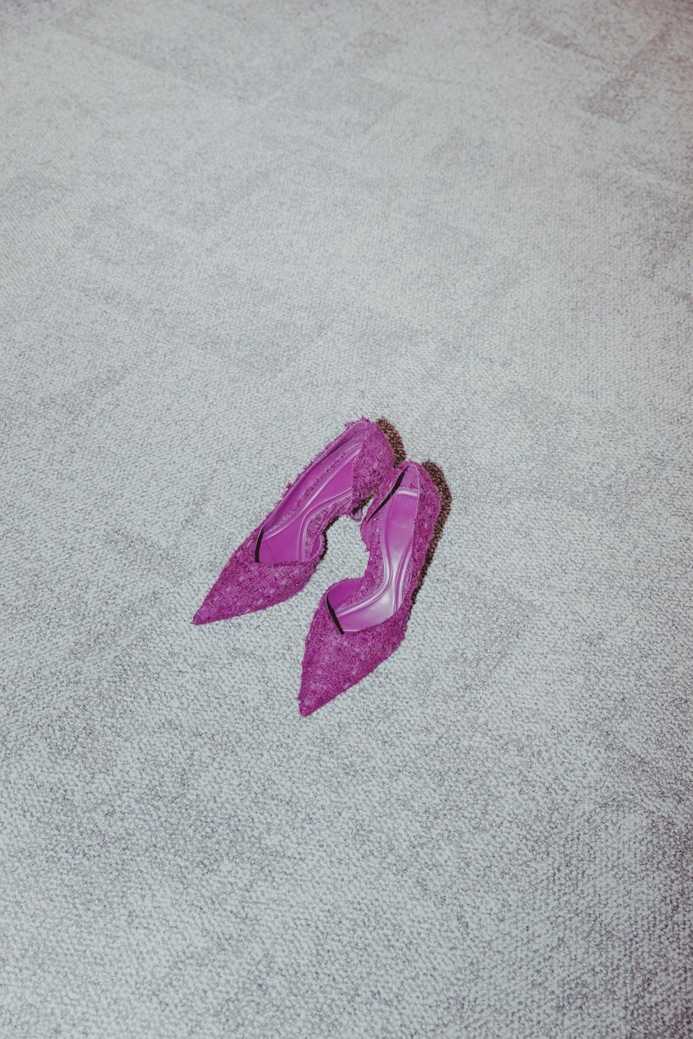 a pair of purple shoes laying on the floor