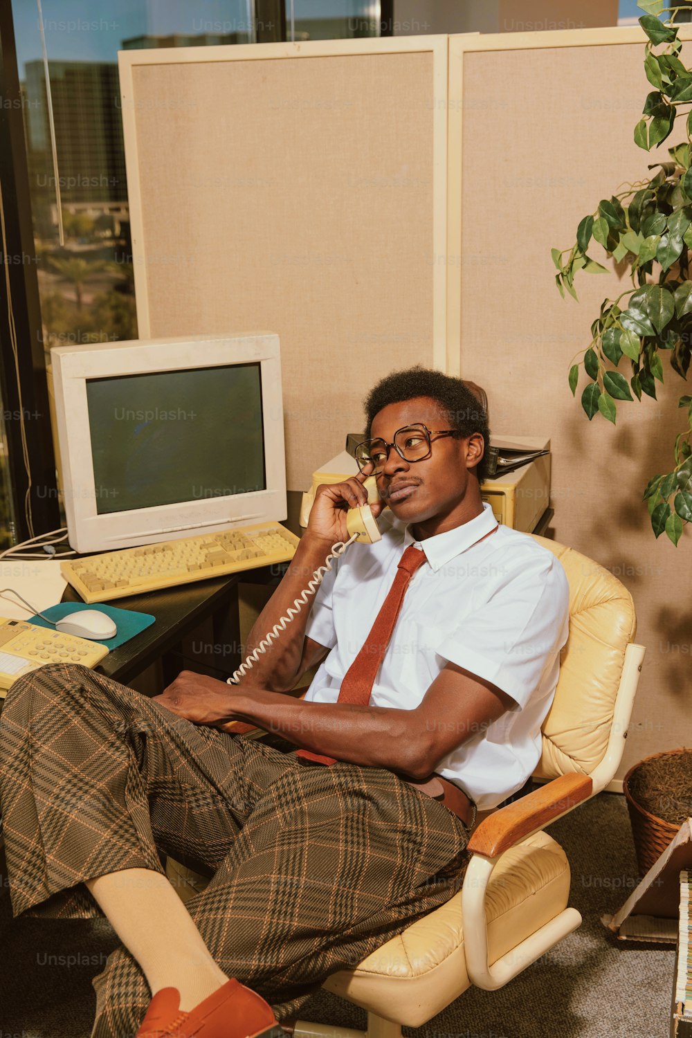 a man sitting in a chair talking on a phone