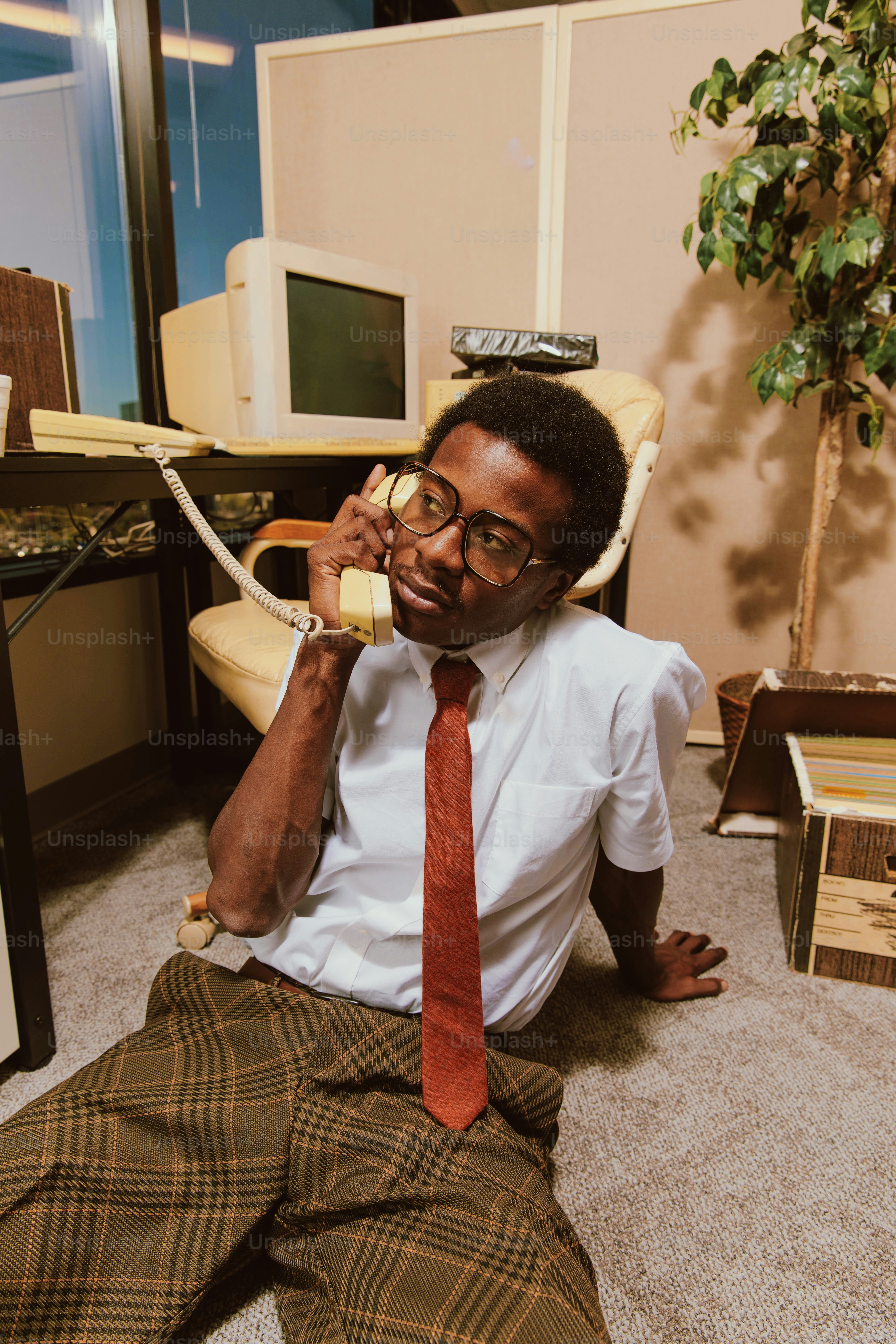 a man sitting on the floor talking on a phone