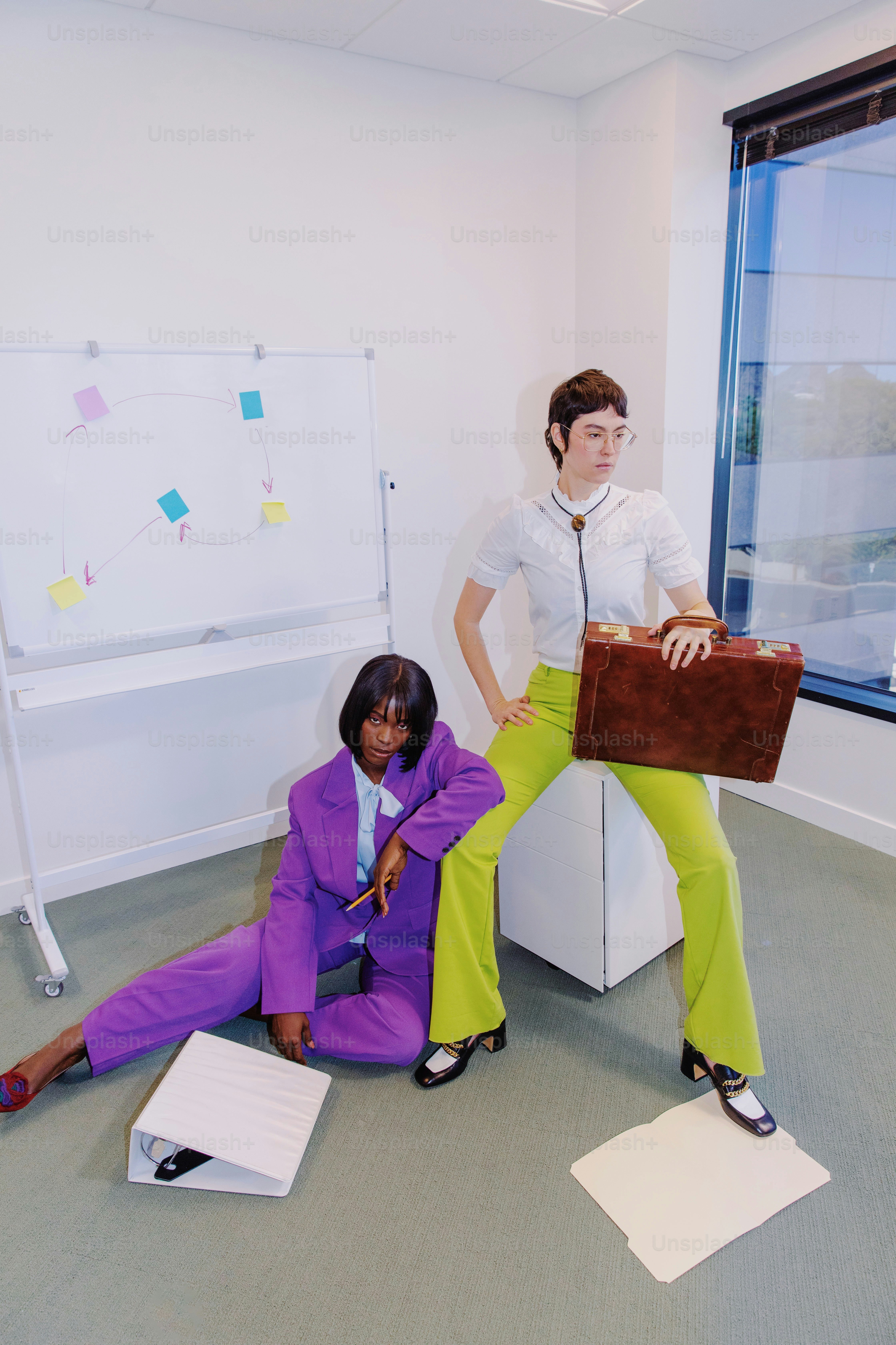 una donna in camicia bianca e una donna in abito viola