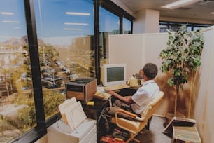 un homme assis à un bureau devant un ordinateur