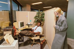 a woman standing next to a man in an office