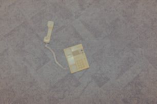 un téléphone posé sur le sol avec un cordon attaché à celui-ci