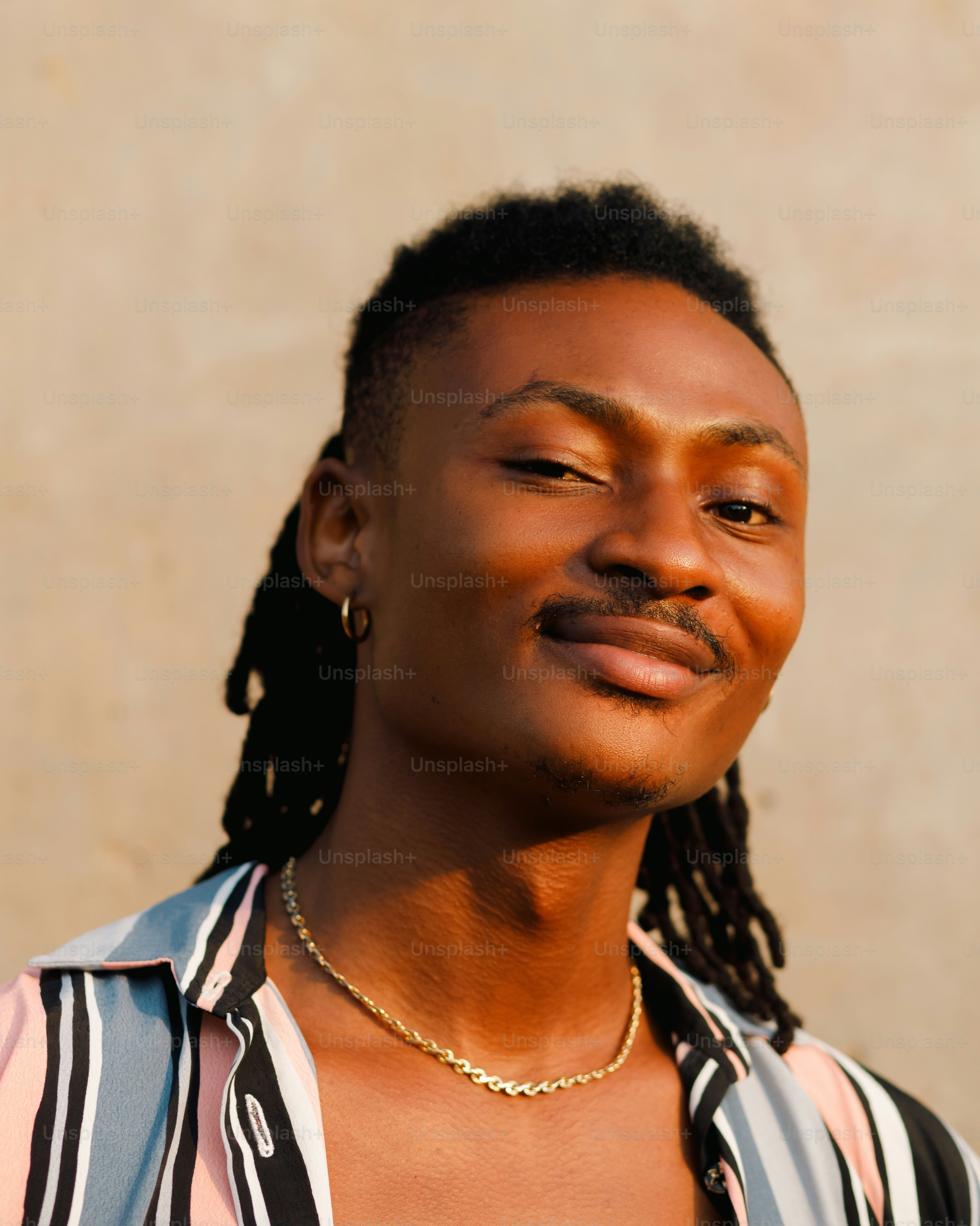 a man with dreadlocks and a striped shirt