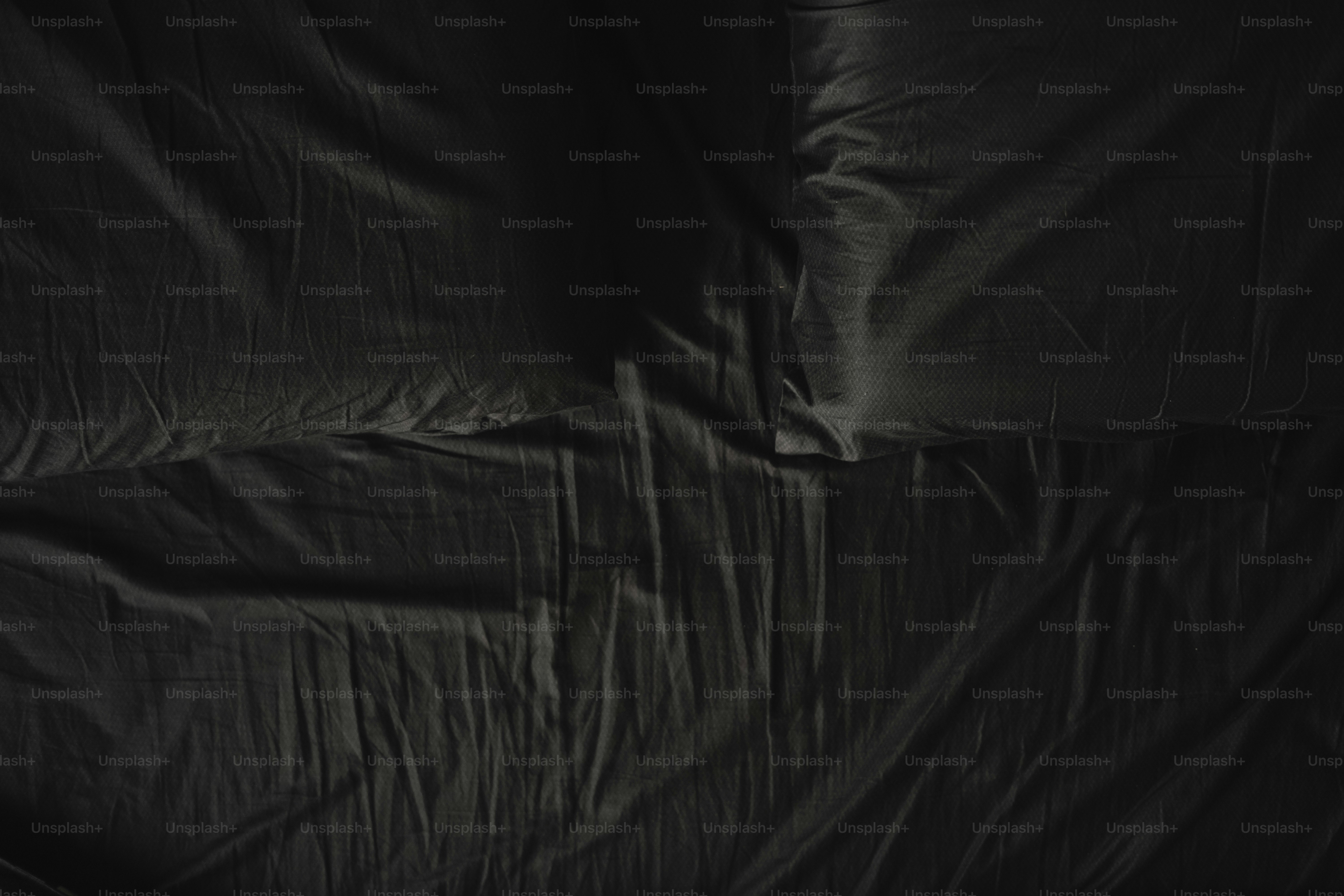 tempat tidur dengan seprai hitam menutupinya