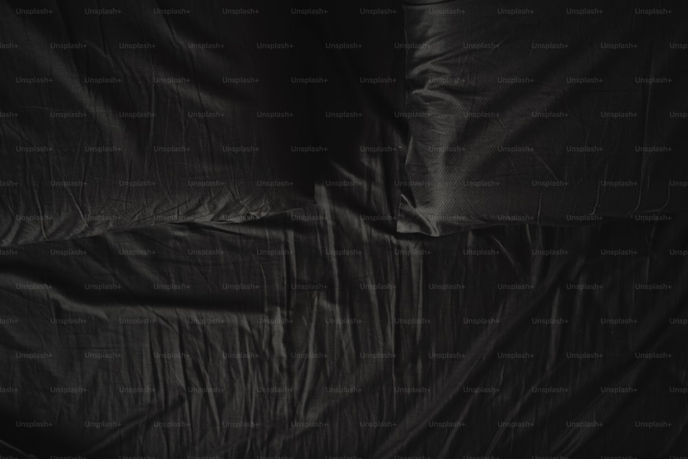 una cama con una sábana negra que la cubre