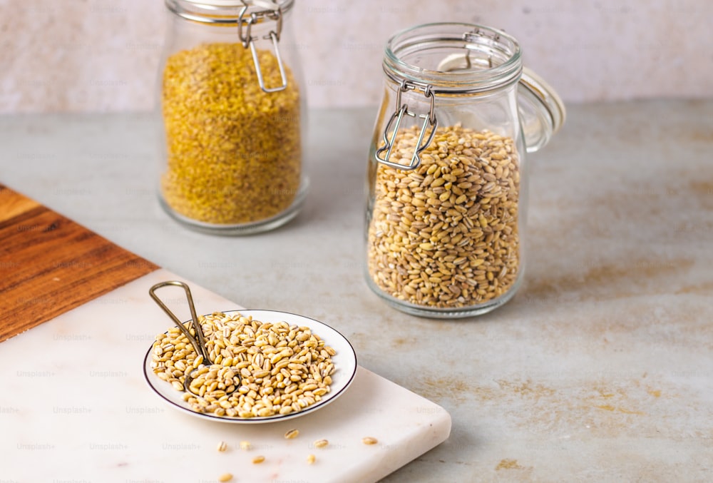 a couple of jars filled with grains on top of a table