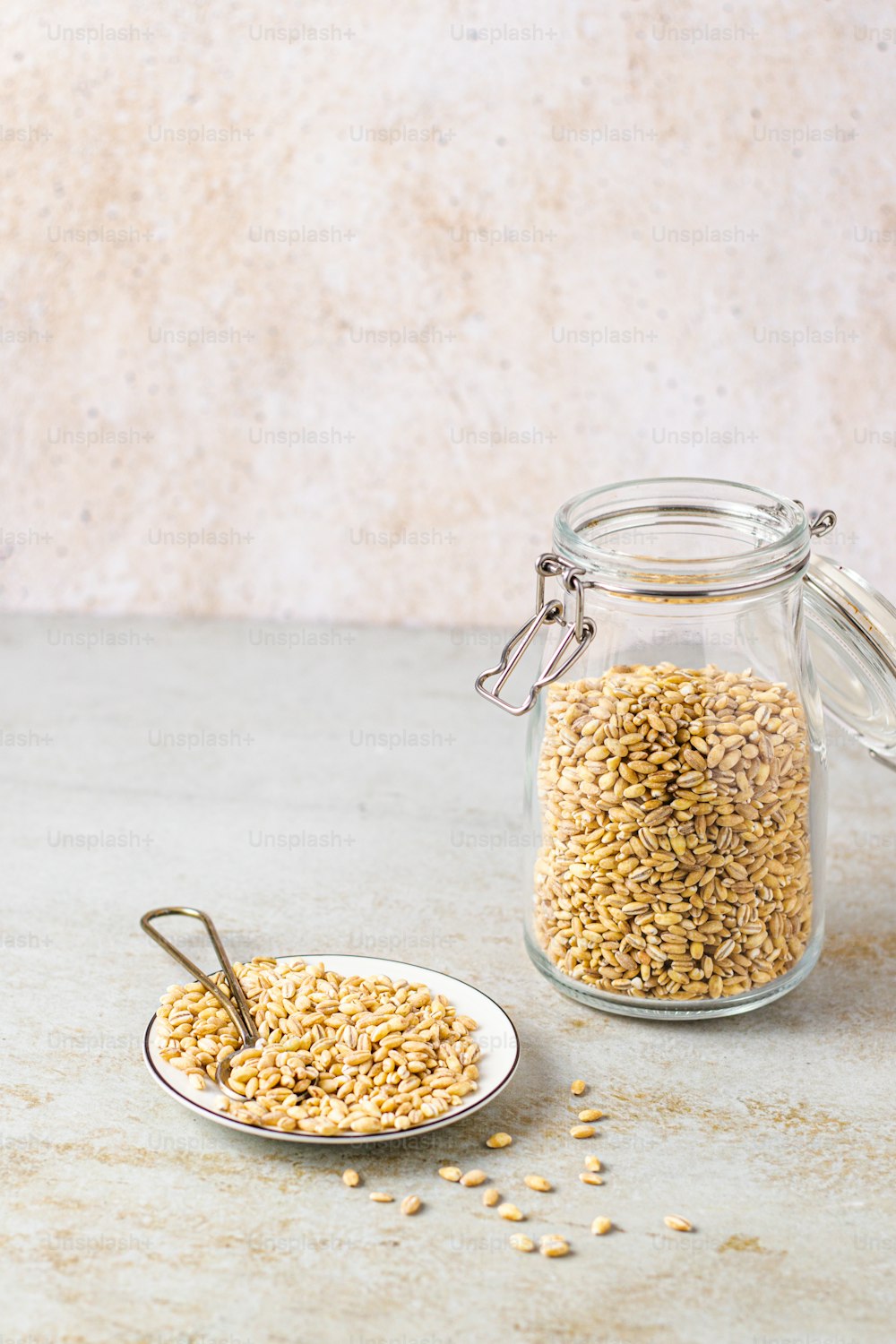 a glass jar filled with grains next to a spoon