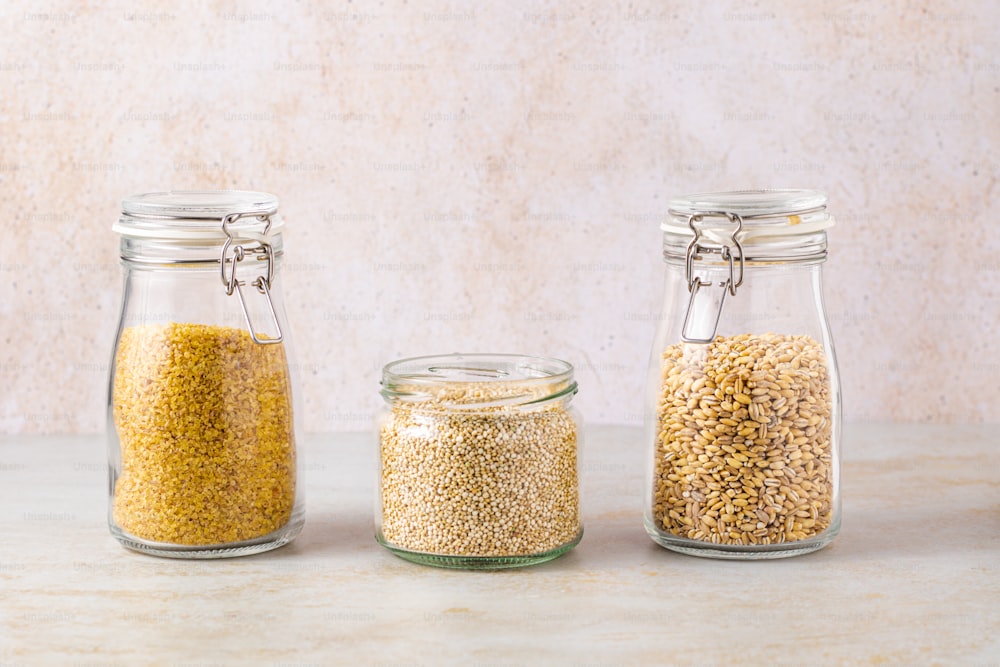 three jars filled with different types of grains