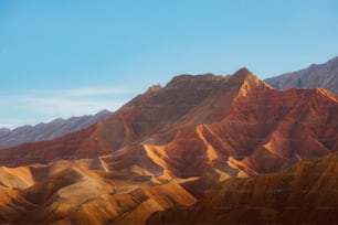 a mountain range with a blue sky in the background