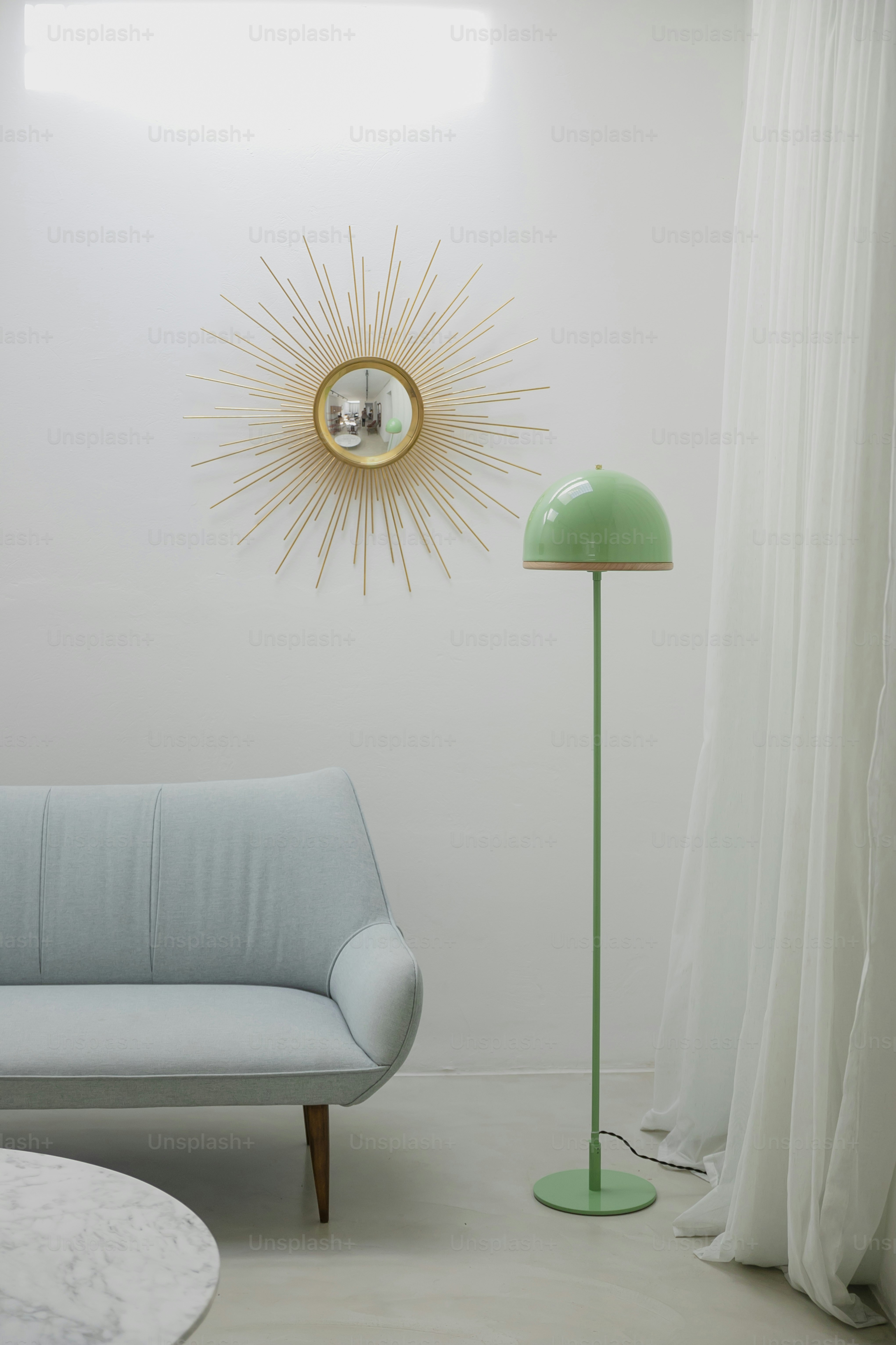 a living room with a blue couch and a green lamp