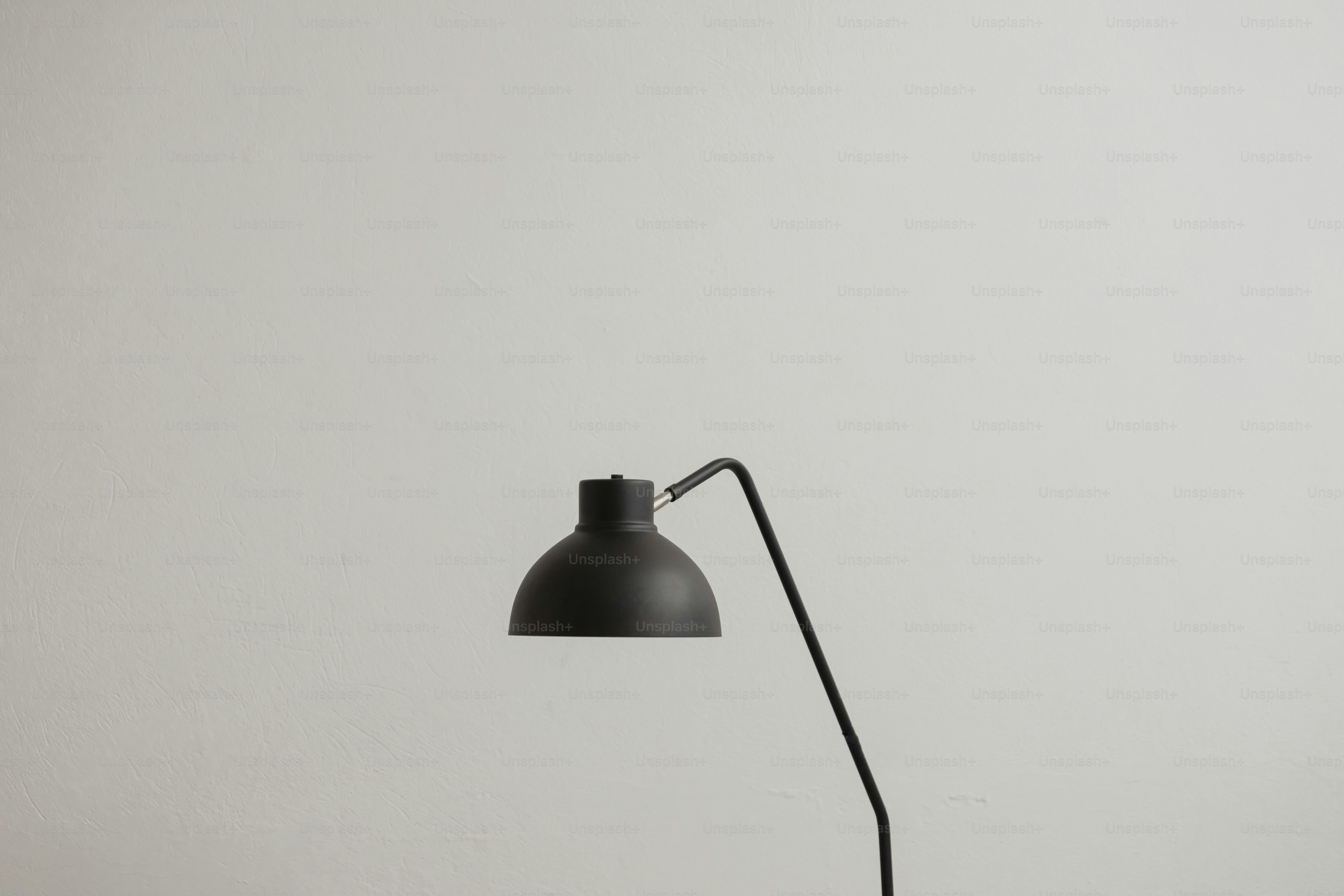 a black table lamp on a white wall