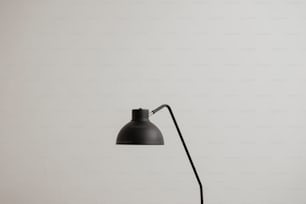 um candeeiro de mesa preto em uma parede branca