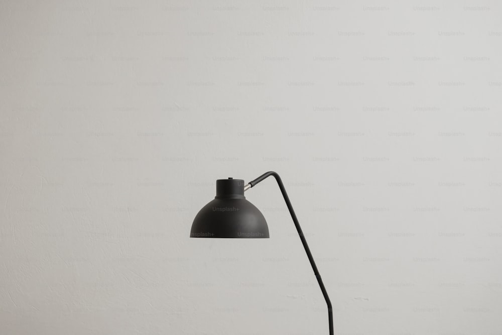 eine schwarze Tischlampe an einer weißen Wand