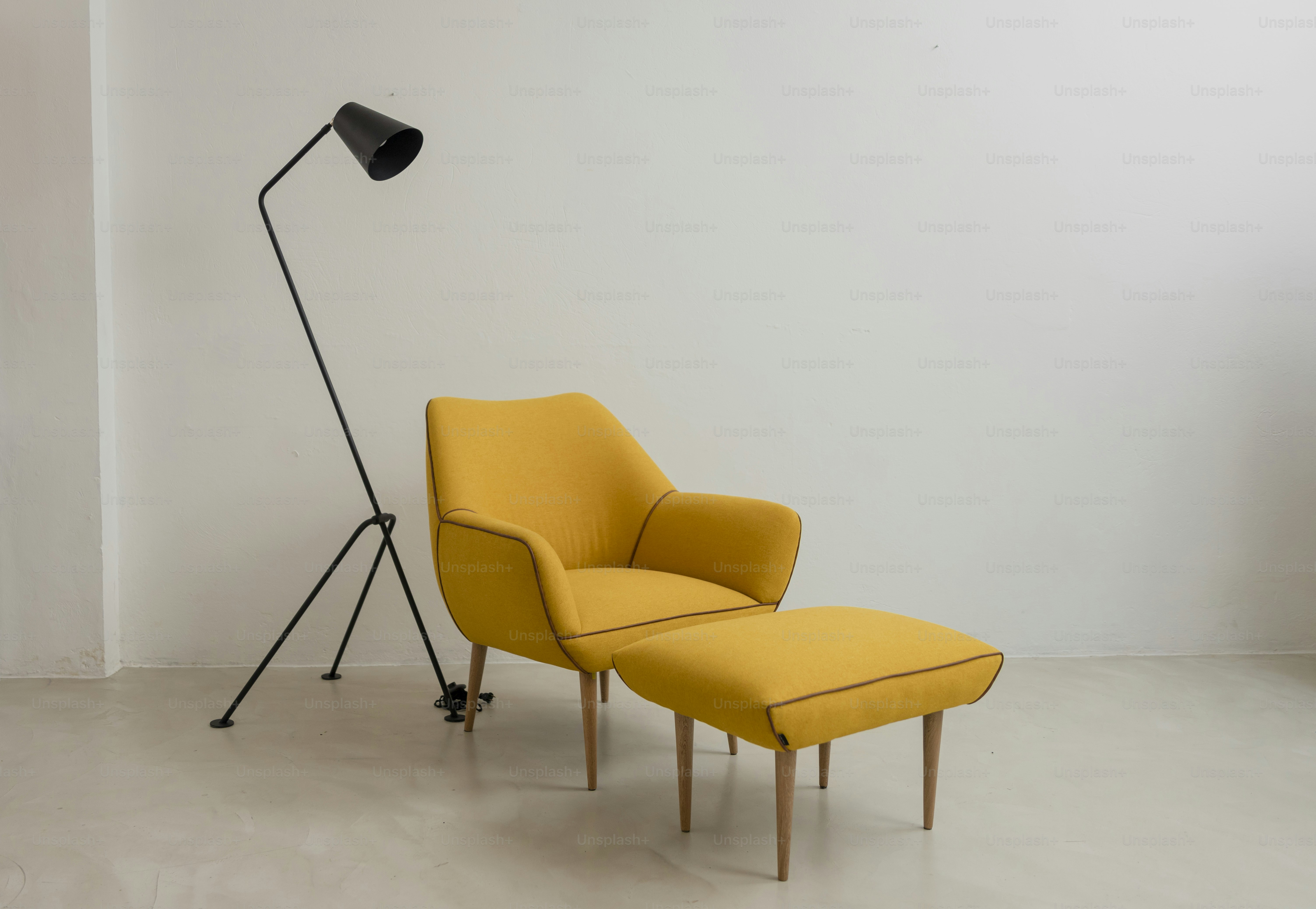 a yellow chair and a black lamp in a room