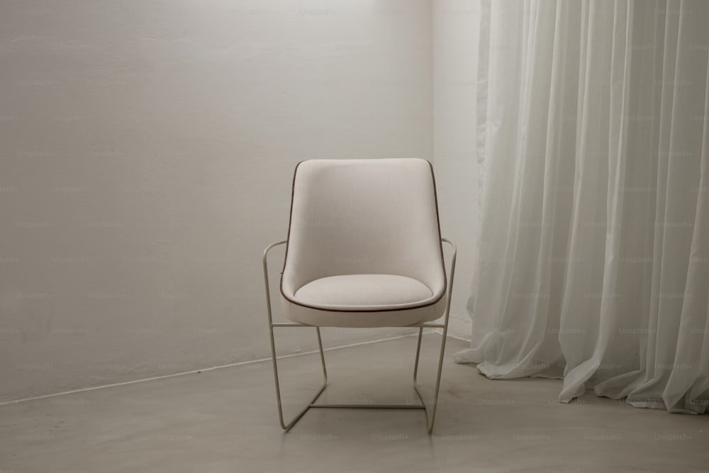 커튼 앞에 앉아있는 흰색 의자