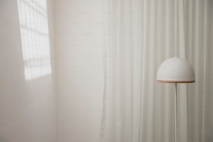 a white lamp sitting next to a white curtain