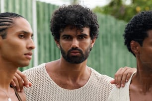 a group of three men standing next to each other