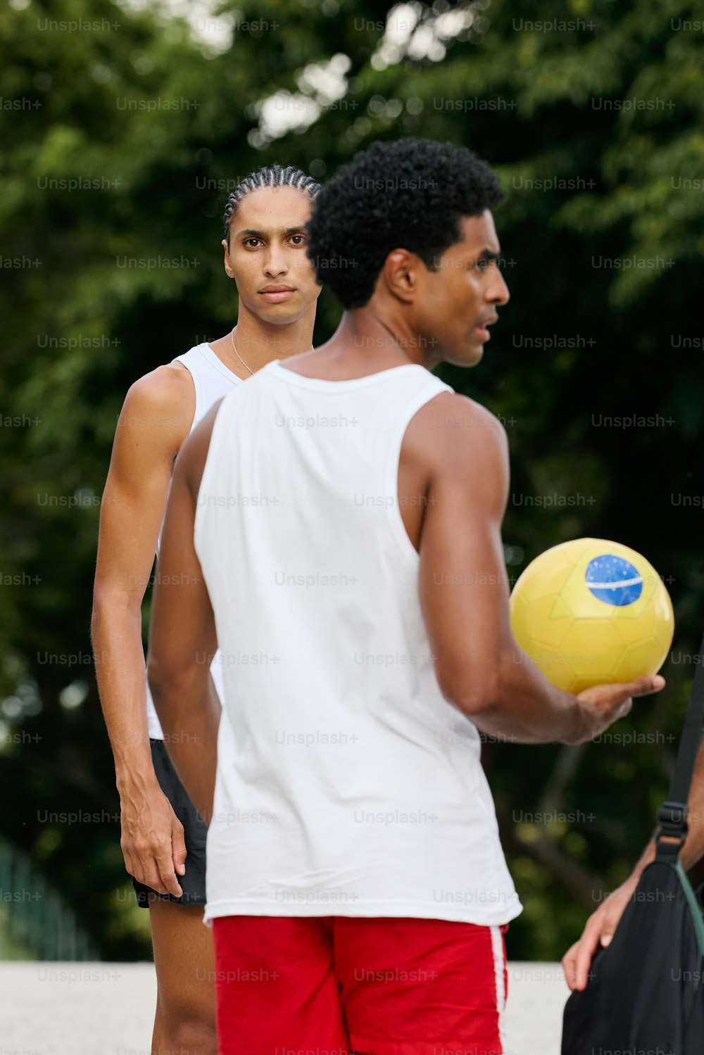 Un hombre sosteniendo un frisbee amarillo junto a otro hombre