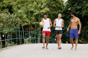 a group of three men walking across a bridge