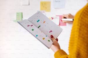 a woman is holding a planner in her hand