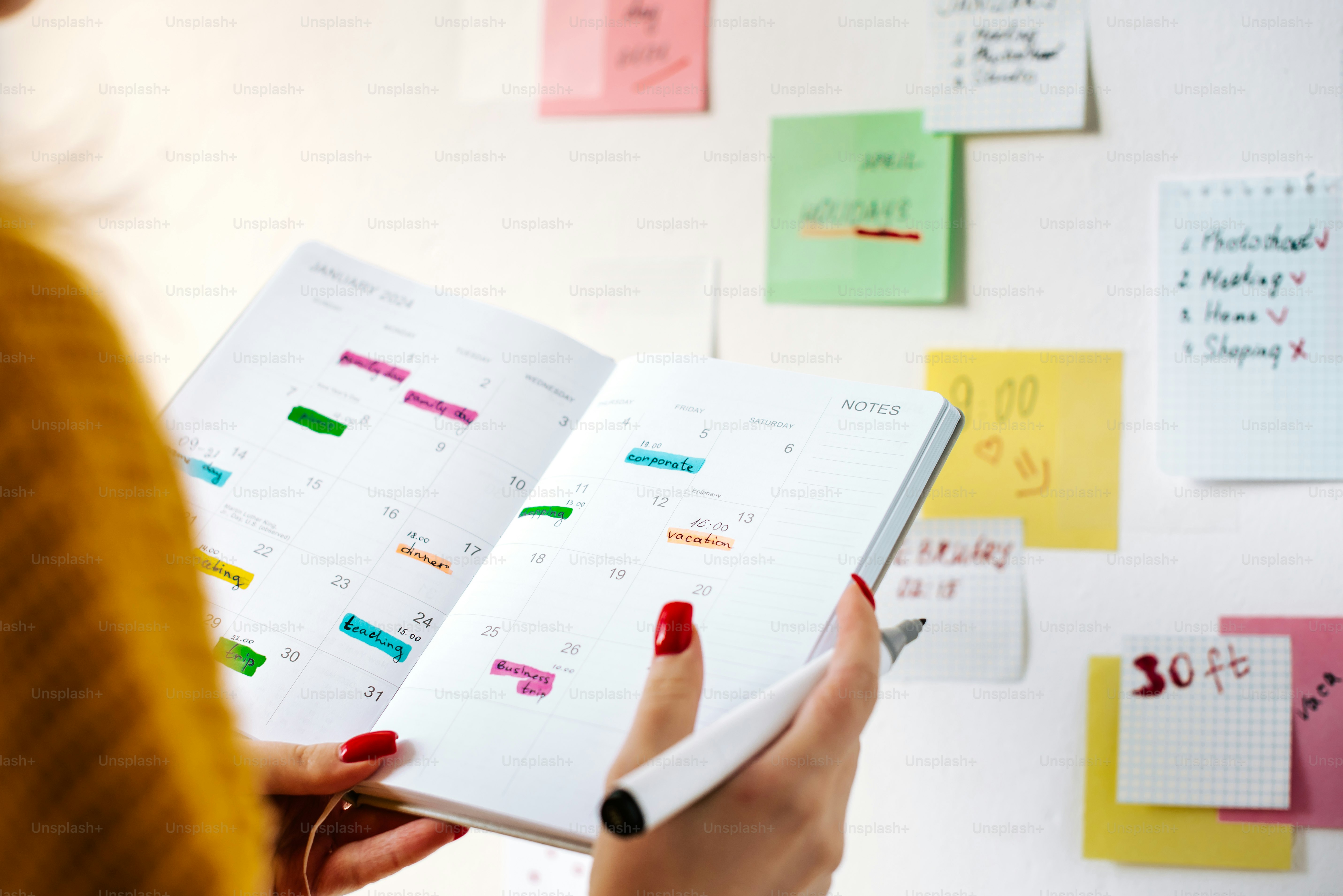 a woman is holding a planner in her hand