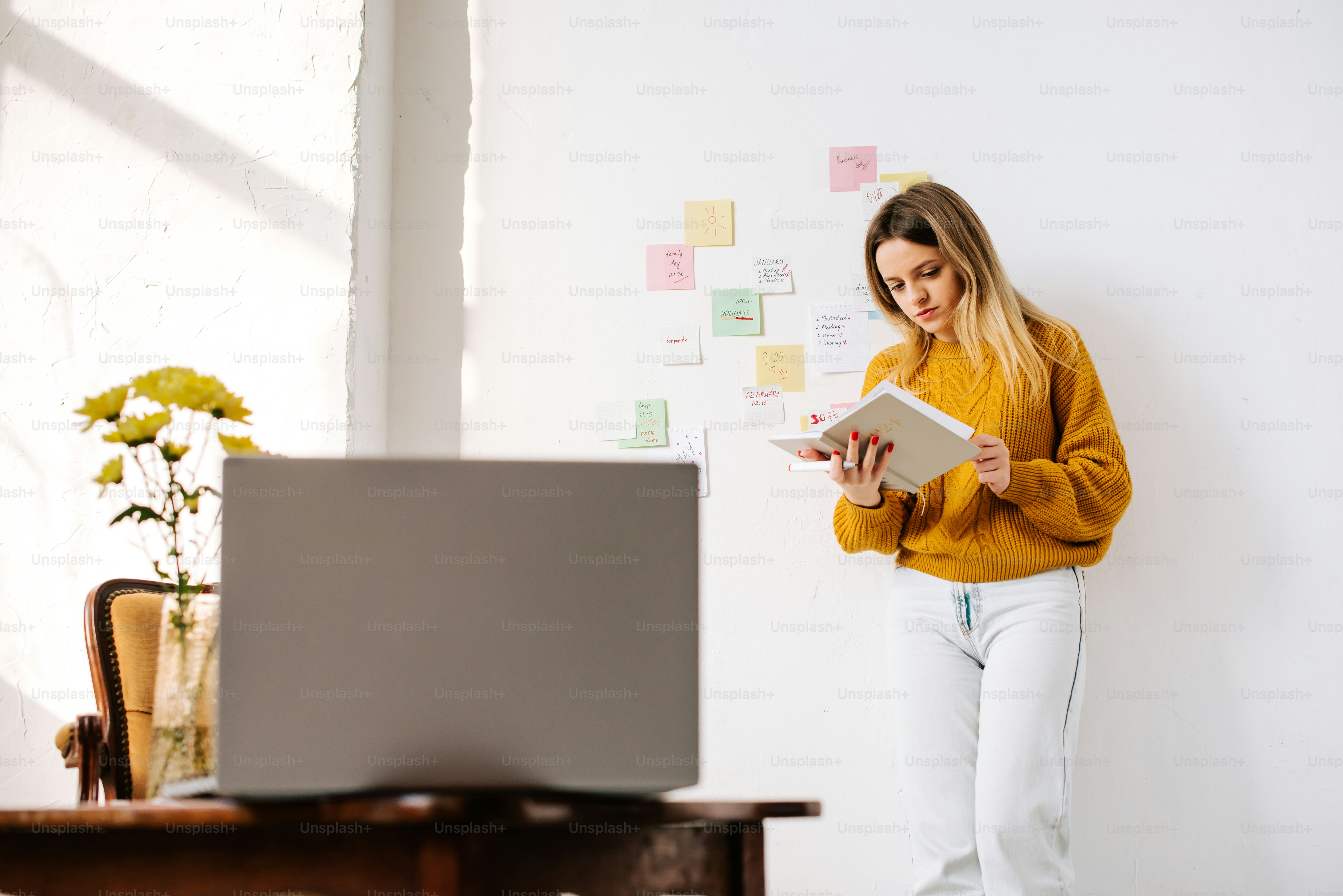 a woman standing in front of a computer holding a book