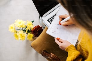 a woman sitting at a desk writing on a notepad