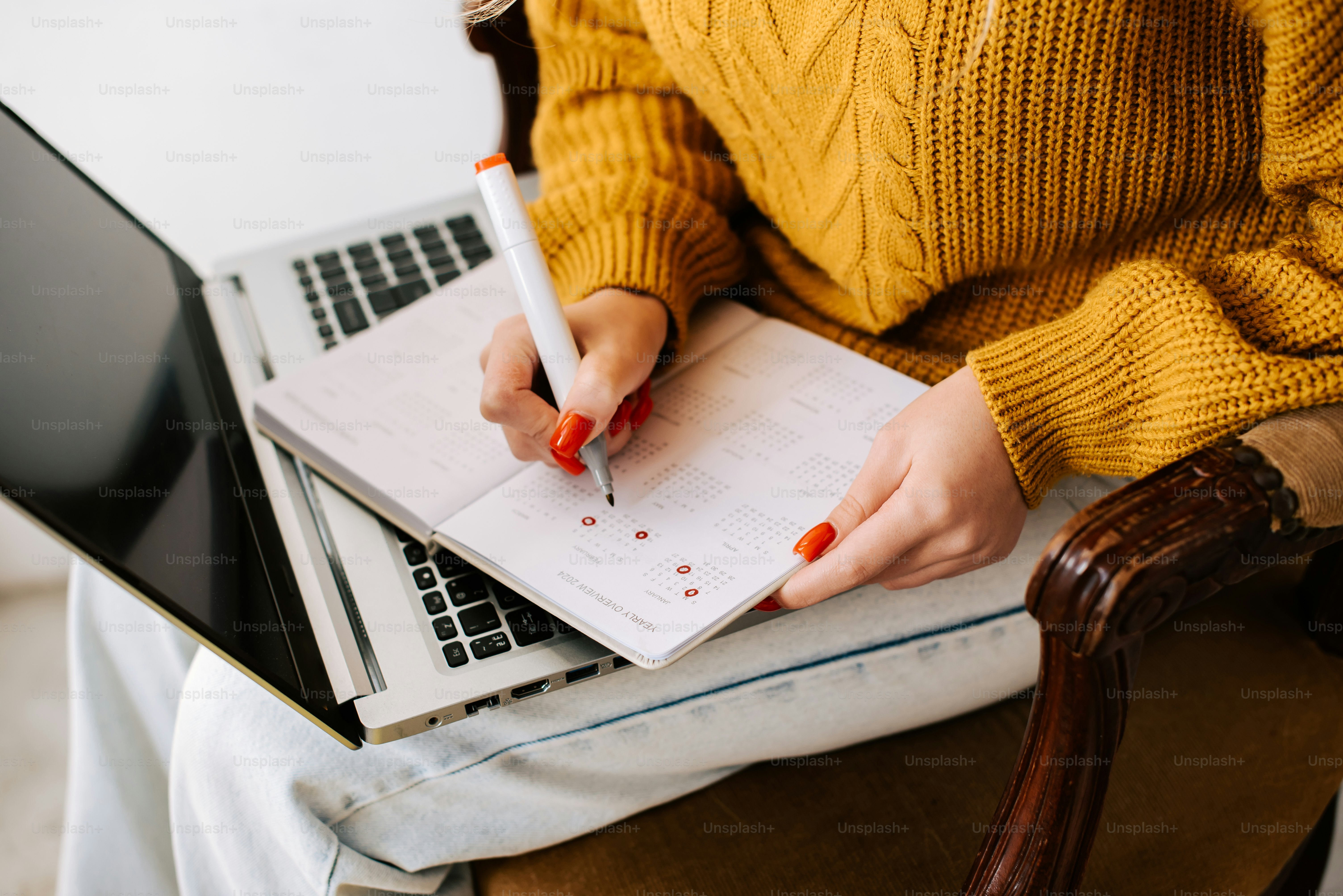 a woman sitting in a chair writing on a notebook